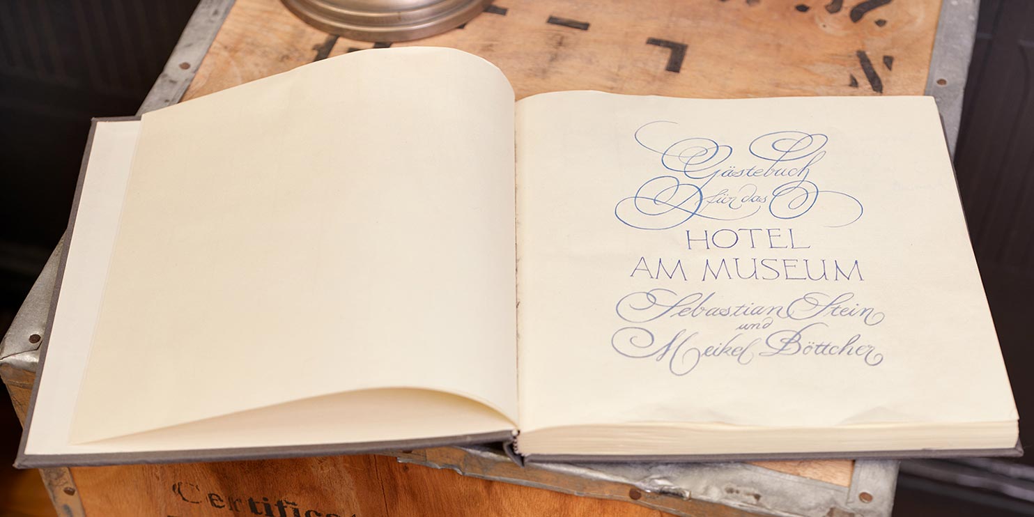 Aufgeschlagenes Gästebuch des Hotel am Museum mit handgeschriebener Widmung