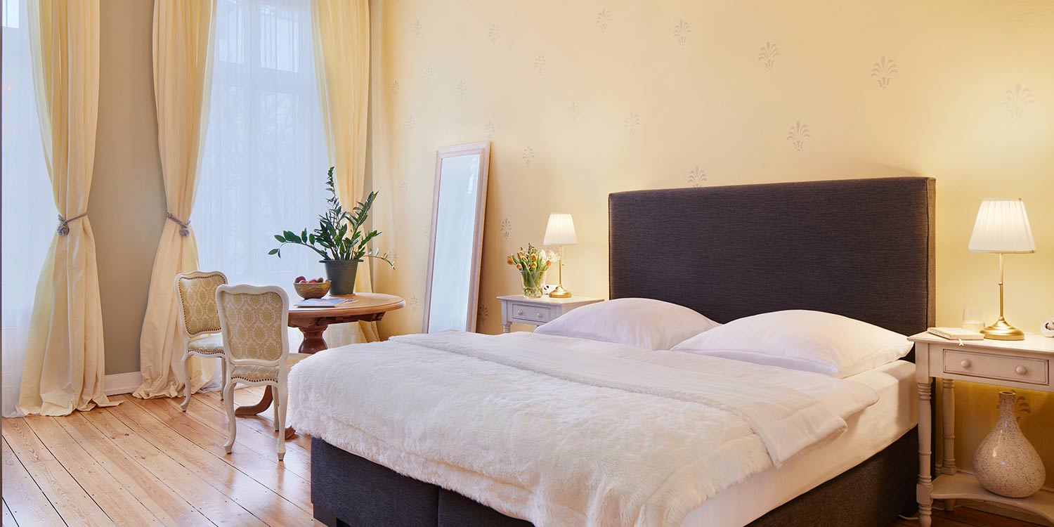 Doppelzimmer Deluxe im Hotel am Museum mit Doppelbett, Sitzecke und warmem Licht